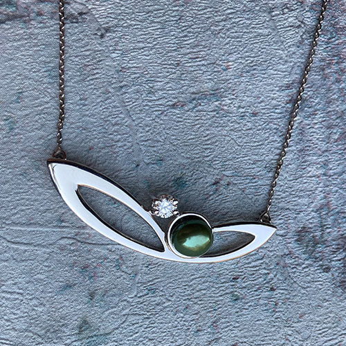White gold pendant with a pearl in a rub over setting
